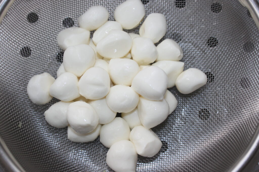 Un escurridor lleno de bolitas redondas de mozza, perfectas para acompañar la mayonesa de wasabi.