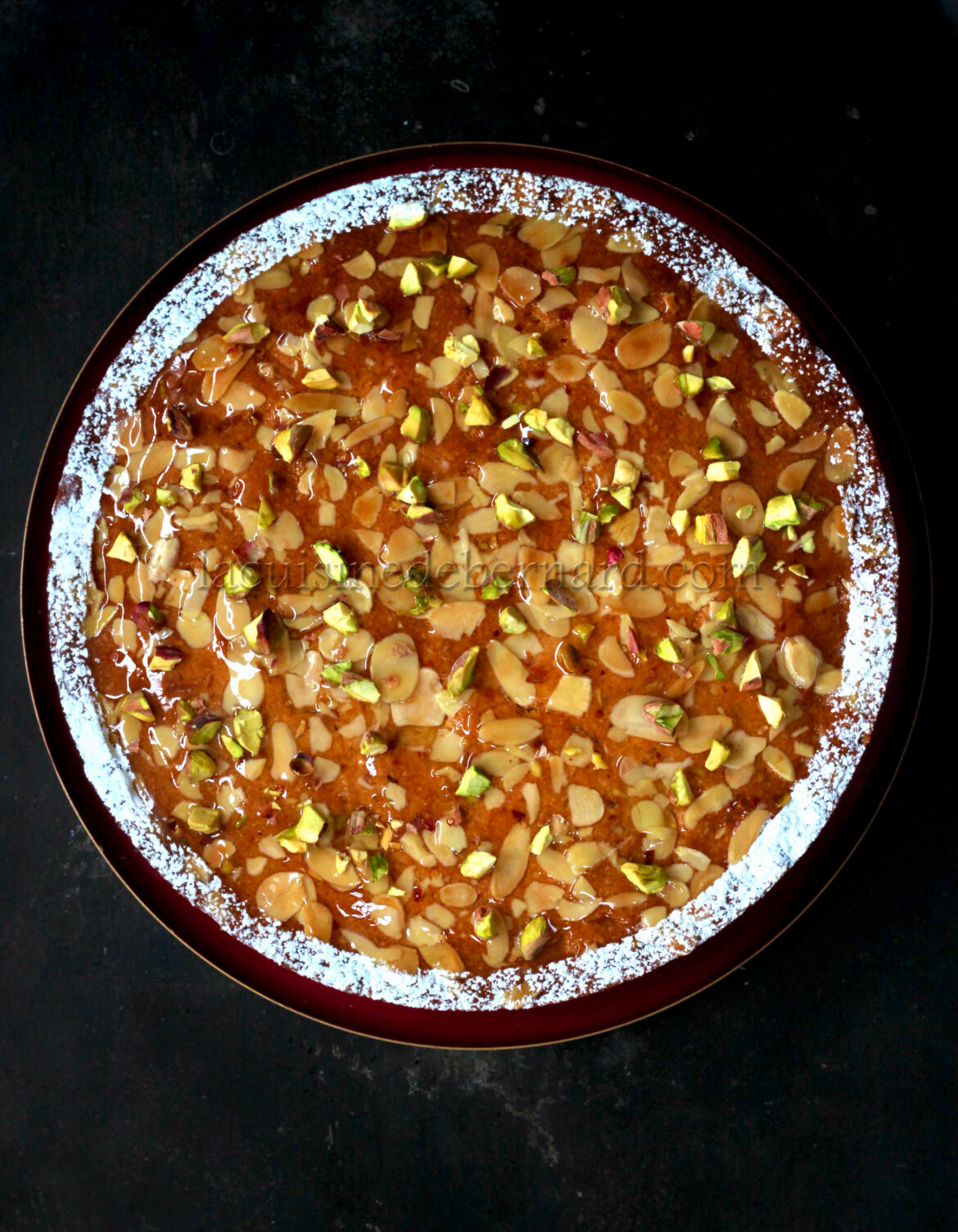 Un pastel con nueces y pistachos en un plato.